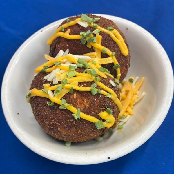 Two Phat Daddy's BBQ deep-fried mac and cheese balls, drizzled with cheese sauce and chives.