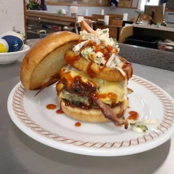 A Phat Daddy's BBQ burger with cheese, bacon, onion rings, coleslaw, and BBQ sauce.